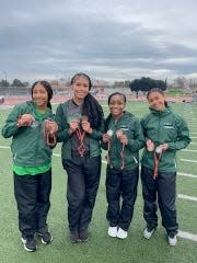 Members of St. Mary's High School girls' track and field team pose for a photo showing off their medals from a track meet during the 2023-24 season.