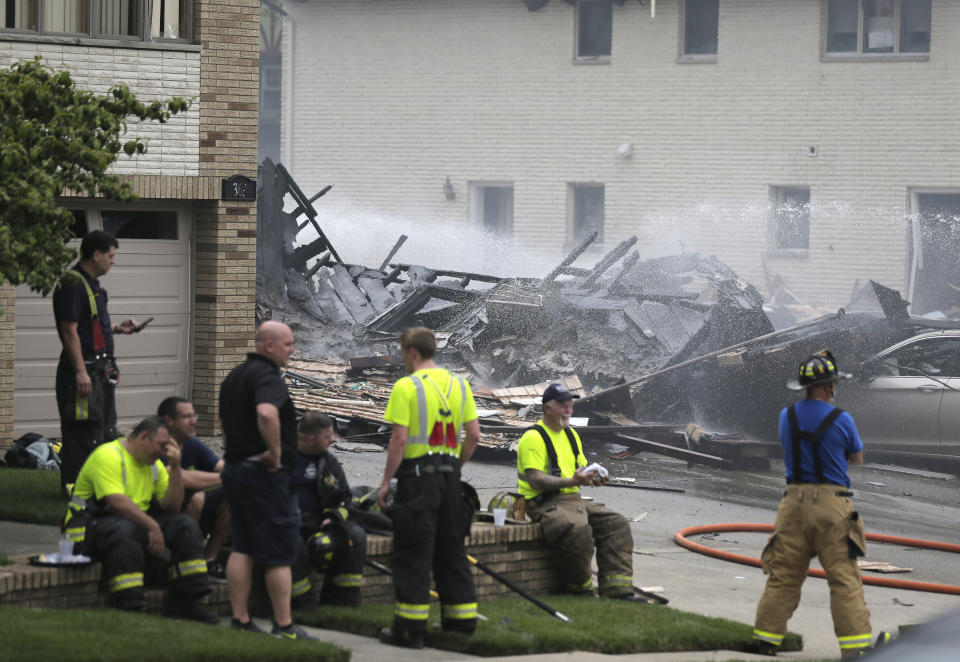 Firefighters and other emergency personnel work at the site of house explosion in Ridgefield, N.J., Monday, June 17, 2019. A home in northern New Jersey has been leveled by an explosion, but the lone person inside the residence apparently escaped serious injury. (AP Photo/Seth Wenig)