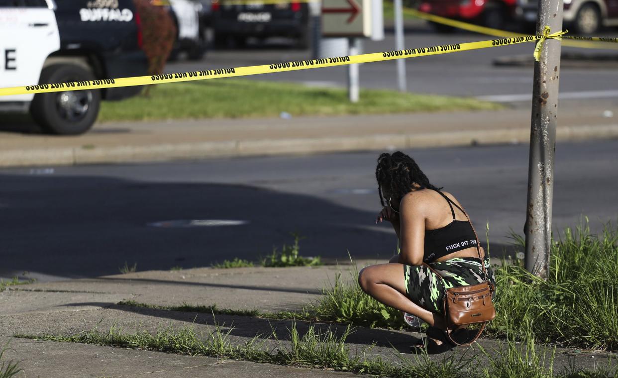 A bystander watches as police investigate after a shooting at a supermarket on Saturday, May 14, 2022, in Buffalo, N.Y.