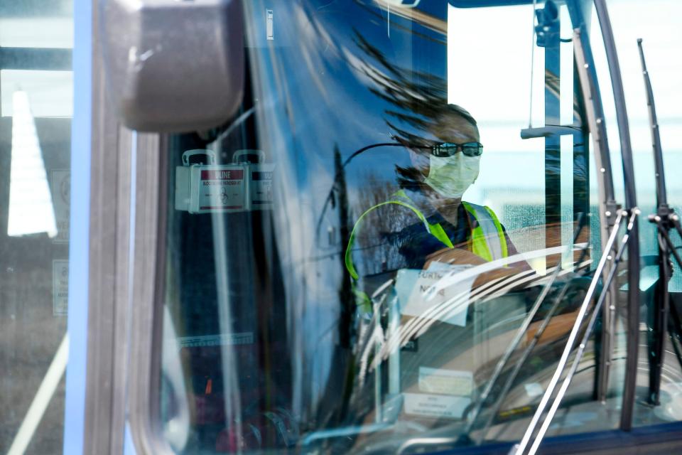 An Asheville Regional Transit driver wears a mask while driving down Haywood Road in West Asheville March 26, 2020. ART buses began limiting riders to 10, including the driver, March 25.