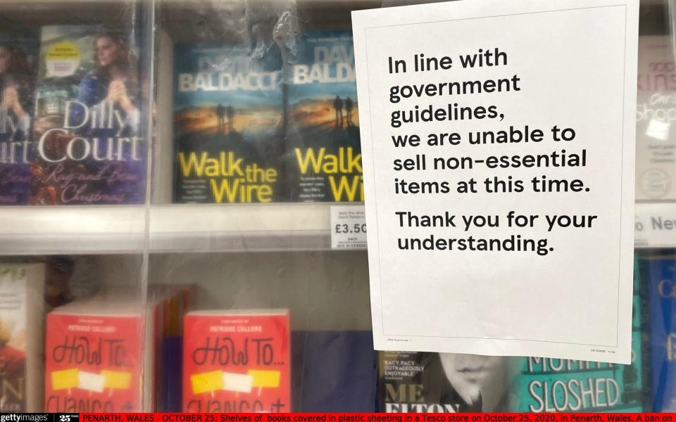 Shelves of books covered in plastic sheeting in a Tesco in Penarth, Wales - Getty Images