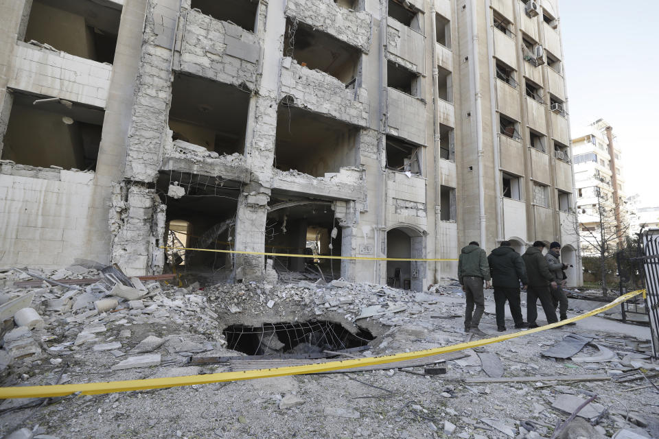 Syrian security officers inspect the damage in a residential neighborhood after an early morning Israeli airstrike in the capital city of Damascus, Syria, Sunday, Feb. 19, 2023. Syrian state news reported that Israeli airstrikes have targeted a residential neighborhood in central Damascus. (AP Photo/Omar Sanadiki)