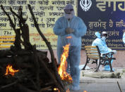 A family member prays as he perform the last rites of a relative who died of COVID-19, at a crematorium in Jammu, India, Friday, April 23, 2021. India’s underfunded health system is tattering as the world’s worst coronavirus surge wears out the nation, which set another global record in daily infections for a second straight day with 332,730. India has confirmed 16 million cases so far, second only to the United States in a country of nearly 1.4 billion people. (AP Photo/Channi Anand)