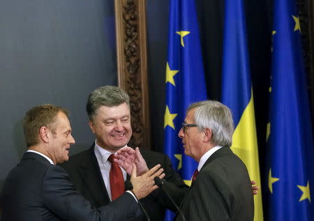 European Council President Donald Tusk (L), European Commission President Jean Claude Juncker (R) and Ukrainian President Petro Poroshenko react during a news conference after their meeting in Kiev April 27, 2015. REUTERS/Gleb Garanich