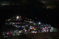 Hundreds of climbers wearing headlamps form a long line as they climb to the summit of Mount Fuji to watch the sunrise, Saturday, Aug. 3, 2019, in Japan. It takes an average hiker five to six hours to reach the summit. Most spend the night in simple mountain huts and start the final ascent in darkness. (AP Photo/Jae C. Hong)