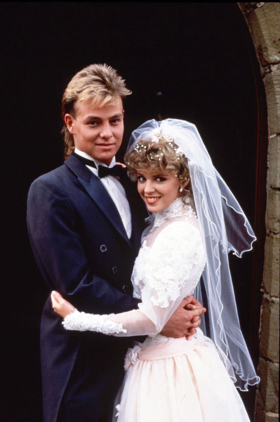 jason donovan as scott, kylie minogue as charlene on their wedding day in neighbours 1988