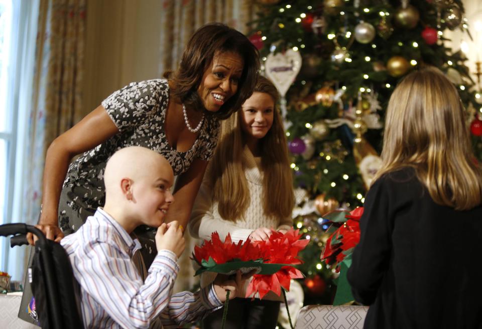 U.S. first lady Michelle Obama meets with the children of U.S. military service members at the unveiling of the Christmas decorations at the White House in Washington, December 4, 2013. REUTERS/Jason Reed (UNITED STATES)