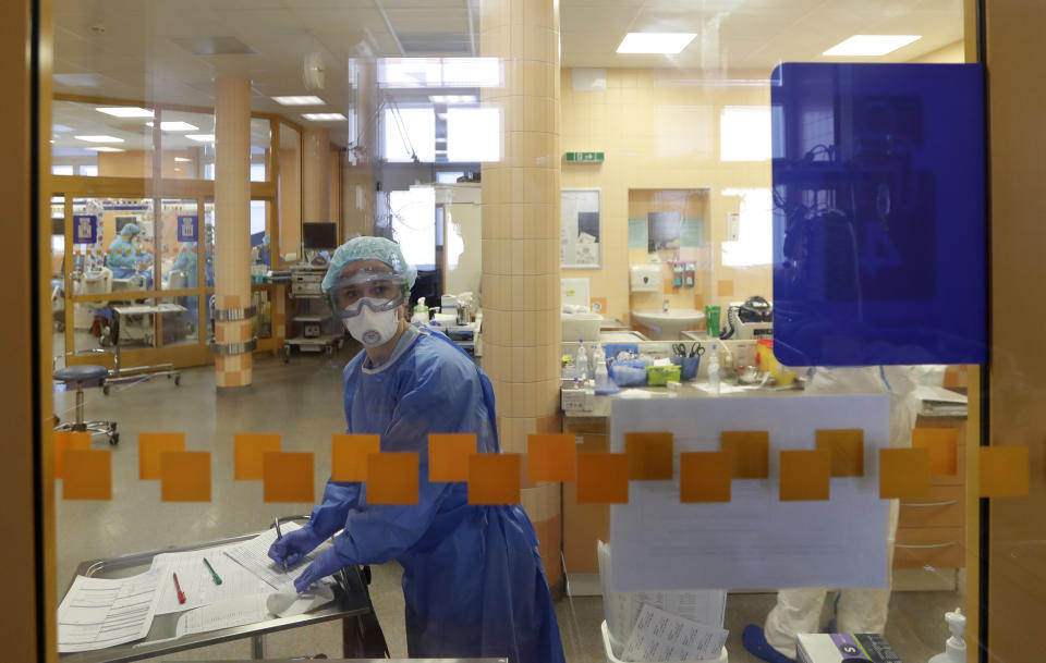 A healthcare worker looks into a room during her shift at an intensive care unit (ICU) at the General University Hospital where patients infected with the COVID-19 are treated in Prague, Czech Republic, Tuesday, April 7, 2020. The new coronavirus causes mild or moderate symptoms for most people, but for some, especially older adults and people with existing health problems, it can cause more severe illness or death. (AP Photo/Petr David Josek)