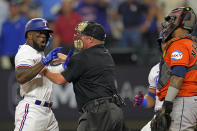 Home Plate umpire Marvin Hudson, center, restrains Texas Rangers' Adolis Garcia, left, as he yells at Houston Astros catcher Martin Maldonado after being hit by a pitch during the eighth inning in Game 5 of the baseball American League Championship Series Friday, Oct. 20, 2023, in Arlington, Texas. (AP Photo/Julio Cortez)