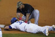Miami Marlins first baseman Jesus Aguilar, top, pats Los Angeles Dodgers' DJ Peters (38) on the back after Peters was called out during the eighth inning of a baseball game Saturday, May 15, 2021, in Los Angeles. Chris Taylor and Luke Raley scored. (AP Photo/Ashley Landis)