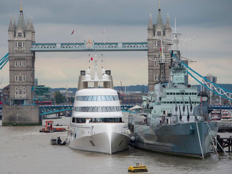 A 390ft motor yacht belonging to Russian tycoon Andrey Melnichenko, alongside HMS Belfast (right) on the River Thames in London.