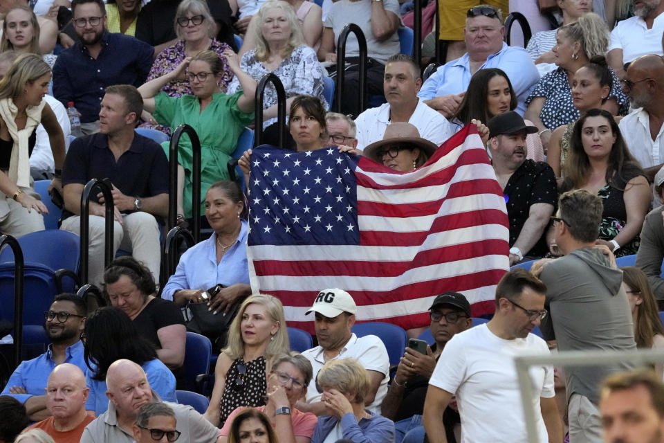 Supporters of Tommy Paul of the U.S. hold up his national flag during his semifinal against Novak Djokovic of Serbia at the Australian Open tennis championship in Melbourne, Australia, Friday, Jan. 27, 2023. (AP Photo/Aaron Favila)