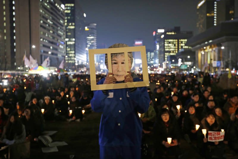 南韓民眾在首爾街頭抗議，要求總統朴槿惠立刻下台。還有人戴上她的面具，暗示總統應該下獄。（美聯社）
