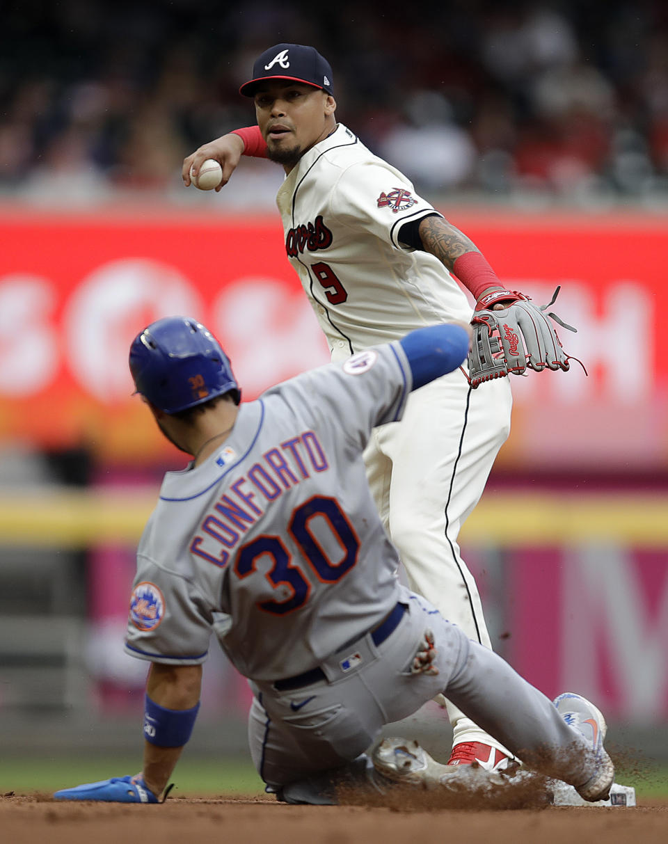 Atlanta Braves' Orlando Arcia, top, prepares to throw over New York Mets' Michael Conforto (30) to complete a double play in the seventh inning of a baseball game Sunday, Oct. 3, 2021, in Atlanta. Mets' Pete Alonso was out at first base. (AP Photo/Ben Margot)