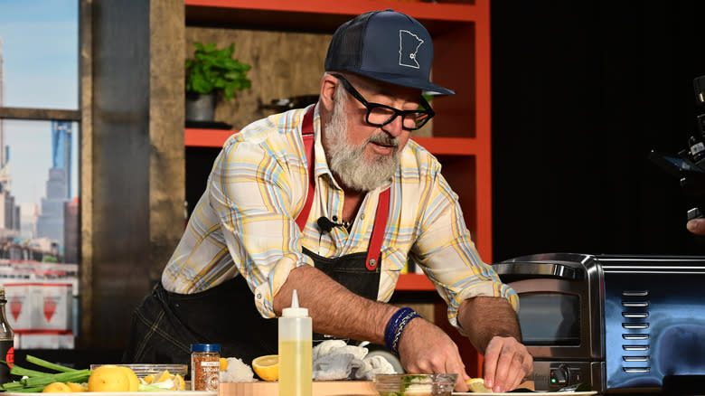 Andrew Zimmern preparing a meal with lemon