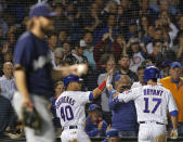 Chicago Cubs' Willson Contreras, center, celebrates scoring a run with Chicago Cubs' Kris Bryant, right, against Milwaukee Brewers' Wade Miley during the fifth inning of a baseball game Monday, Sept. 10, 2018, in Chicago. (AP Photo/Jim Young)