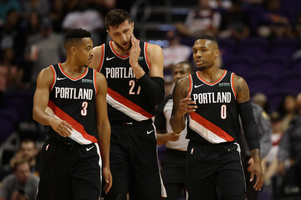 Damian Lillard #0 (R) of the Portland Trail Blazers talks with CJ McCollum #3 and Jusuf Nurkic #27 