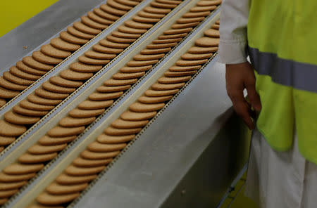 A worker inspects biscuits on the production line of Pladis' McVities factory in London Britain, September 19, 2017. Picture taken September 19, 2017. REUTERS/Peter Nicholls.