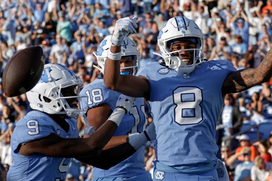 UNC wide receiver Kobe Paysour (8) celebrates his long touchdown reception and run against Syracuse with teammates wide receiver Devontez Walker (9) and tight end Bryson Nesbit (18) during the second half of an NCAA college football game, Saturday, Oct. 7, 2023, in Chapel Hill, N.C. (AP Photo/Chris Seward)