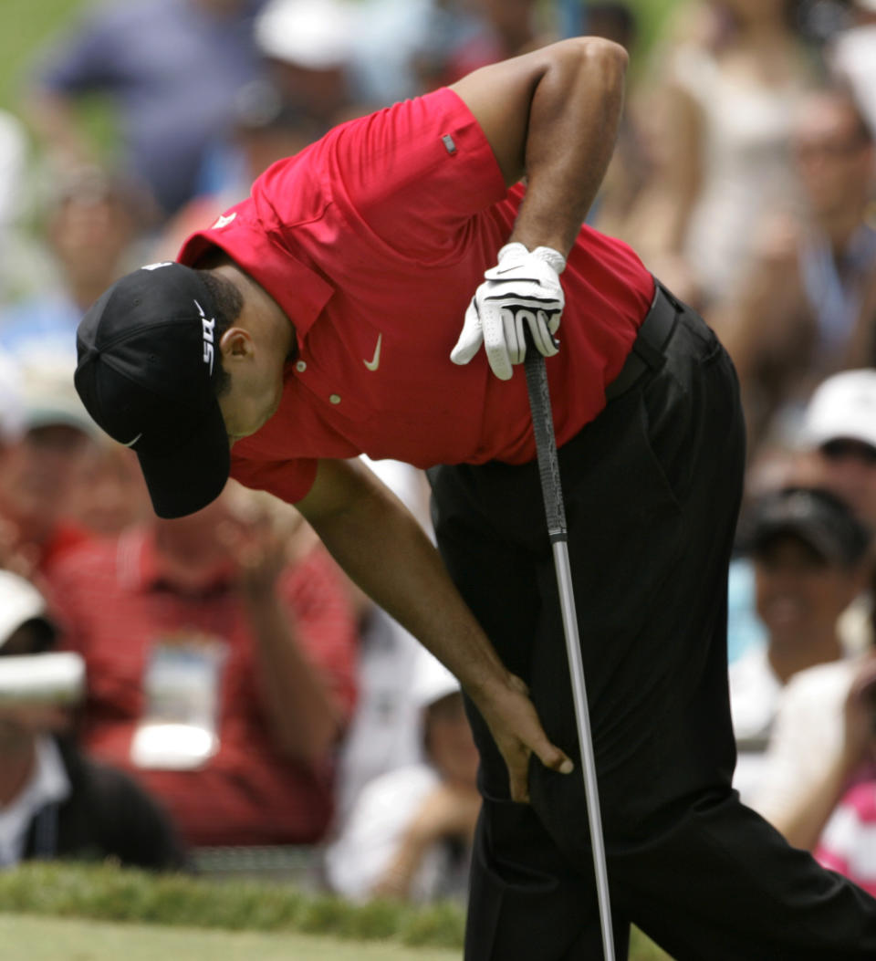 FILE - In this June 15, 2008, file photo, Tiger Woods holds onto his left knee after teeing off on the second hole during the fourth round of the US Open championship at Torrey Pines Golf Course in San Diego. He had a fourth back surgery with hopes of simply playing with his two children, not chasing Jack Nicklaus in history. (AP Photo/Charlie Riedel, File)