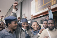 <p>Activist Winnie Mandela raises a clenched fist after appearing briefly in the Johannesburg Magistrate’s Court on Jan. 22, 1986. Mrs. Mandela, who was held by police in Soweto on Sunday for defying her banning order, was released on her own recognizance and ordered to appear in the Krugersdorp Magistrate’s Court, west of Johannesburg. (Photo: Greg English/AP) </p>