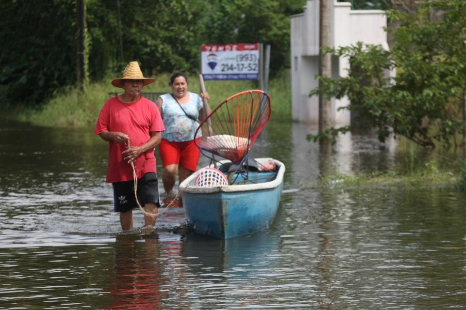 Habitantes de Ixtacomitan abandonan sus hogares debido a las inundaciones por las intensas lluvias.