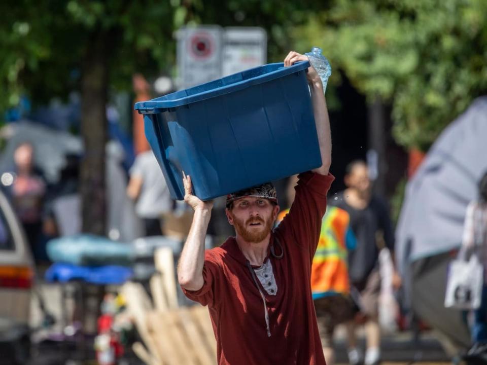 Tents are pictured being dismantled on East Hastings Street on the Downtown Eastside neighbourhood in Vancouver, British Columbia on Tuesday, Aug. 9, 2022.  (Ben Nelms/CBC - image credit)