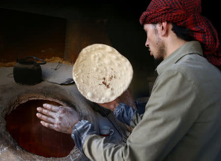 A man makes bread in the town of Hamoria, eastern Ghouta in Damascus, Syria, November 29, 2017. REUTERS/Bassam Khabieh