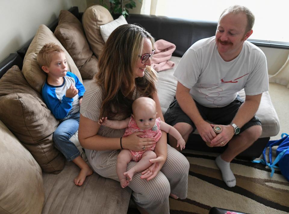 Preston Leonard sits behind his parents Ashley and Jason Leonard as they relax with Preston's little sister Kayleigh, 4 months, after Jason returned home from work on Tuesday, Sept. 13, 2022, at their home in Port St. Lucie. The family is in New York for the first time after Preston was one of 500 winners to be featured on the Jumbotron screen in Times Square.