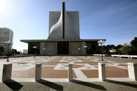 A pedestrian walks across the plaza at St. Mary's Cathedral in San Francisco, California March 19, 2015. REUTERS/Robert Galbraith