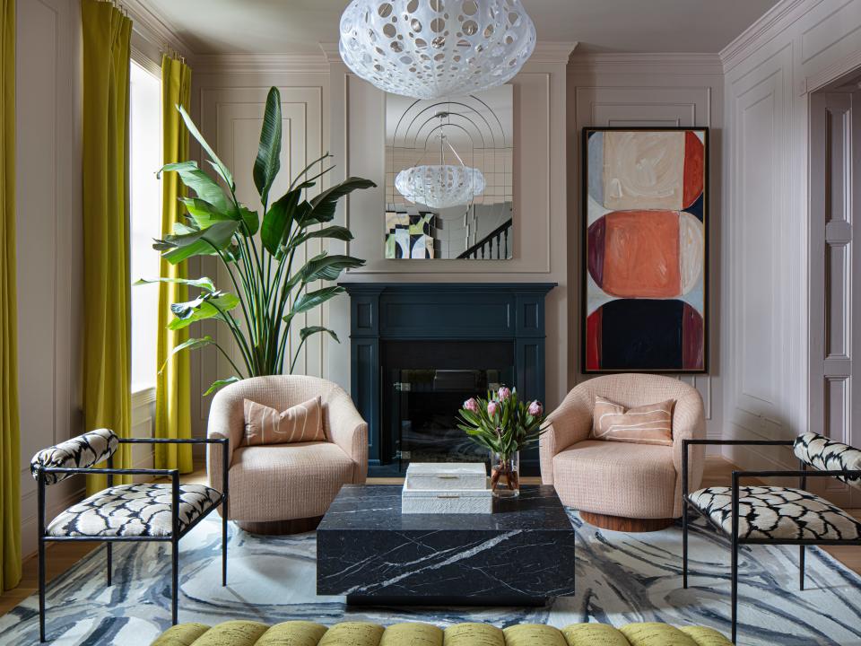 Lindsay Cowles put on her artist hat to create a custom pale pink paint for her front parlor walls by combining two Farrow & Ball colors. “It couldn’t be too beige or too purple,” she says. “It had to have the right amount of gray. It was really tricky.” Jill designed the living room around Lindsay’s Blue Grey Rug, layering in chartreuse draperies, Kelly Wearstler swivel chairs, Oly Studio lighting, pattered armchairs, a custom mirror, and one of Lindsay’s abstract paintings.