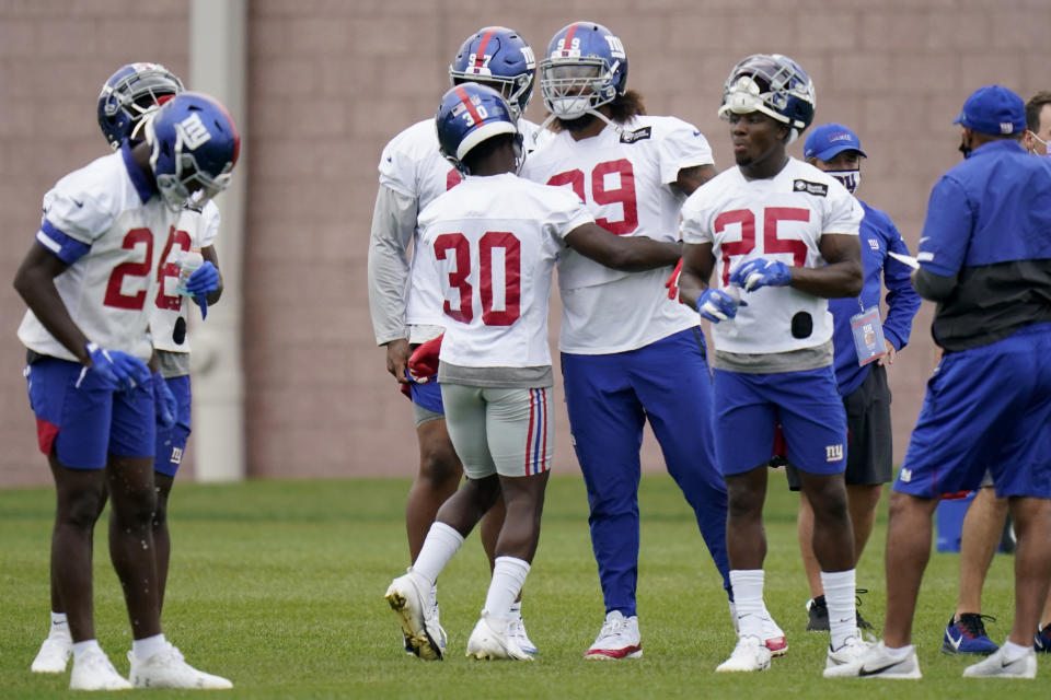 New York Giants' Darnay Holmes (30) gives Leonard Williams a hug during practice at the NFL football team's training camp in East Rutherford, N.J., Wednesday, Aug. 19, 2020. (AP Photo/Seth Wenig)