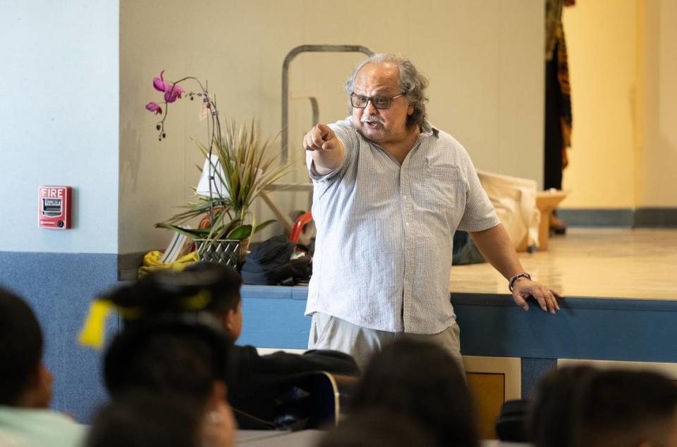 El profesor de Literatura de la Universidad Estatal de Stanislaus, Manuel Murrieta, se divierte con algunos de los estudiantes durante un programa extraescolar de arte en Bret Harte Elementary School, en Modesto, California, el miércoles 22 de mayo de 2024.