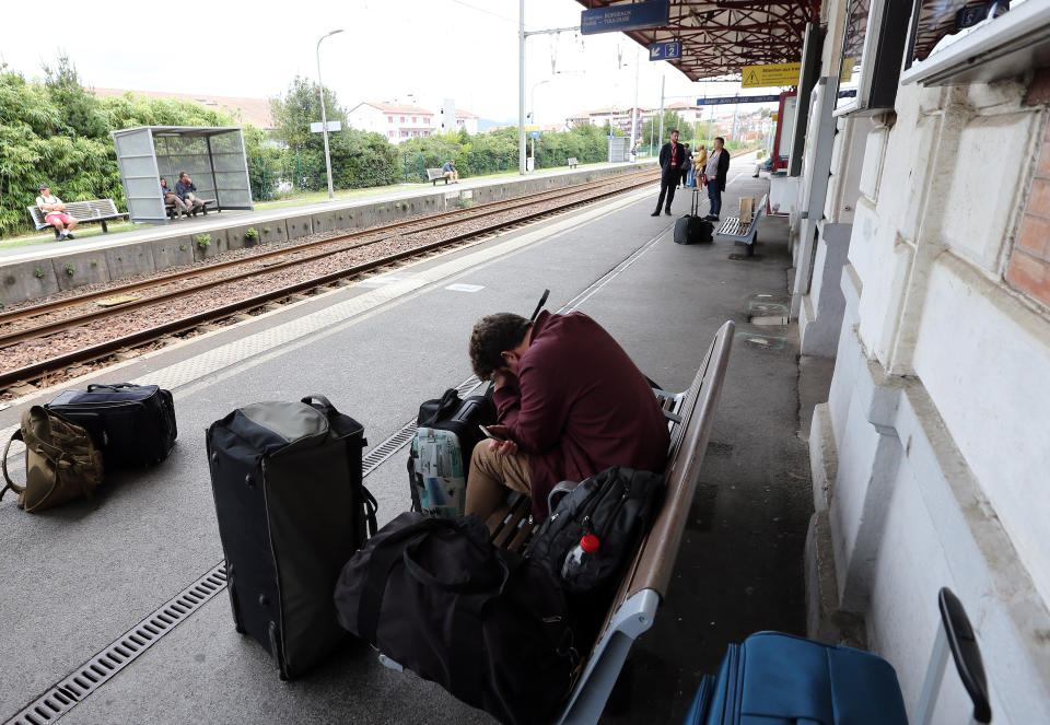 A traveler sleeps on the platform of the station of Saint Jean de Luz, southwestern France, Friday, Oct.18, 2019. A wildcat strike is disrupting train travel around France, as railway workers demand better security after a recent accident. (AP Photo/Bob Edme)