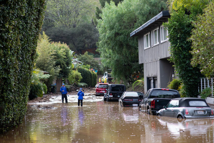 STUDIO CITY, CALIFORNIA - January 10th, 2023: News reporters at a flooded block in a Studio City neighborhood on Tuesday..CREDIT: Alex Welsh for TIME