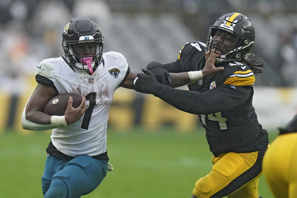 Jacksonville Jaguars running back Travis Etienne Jr. (1) stiff arms Pittsburgh Steelers linebacker Markus Golden (44) on a rush during the first half of an NFL football game Sunday, Oct. 29, 2023, in Pittsburgh. (AP Photo/Matt Freed)