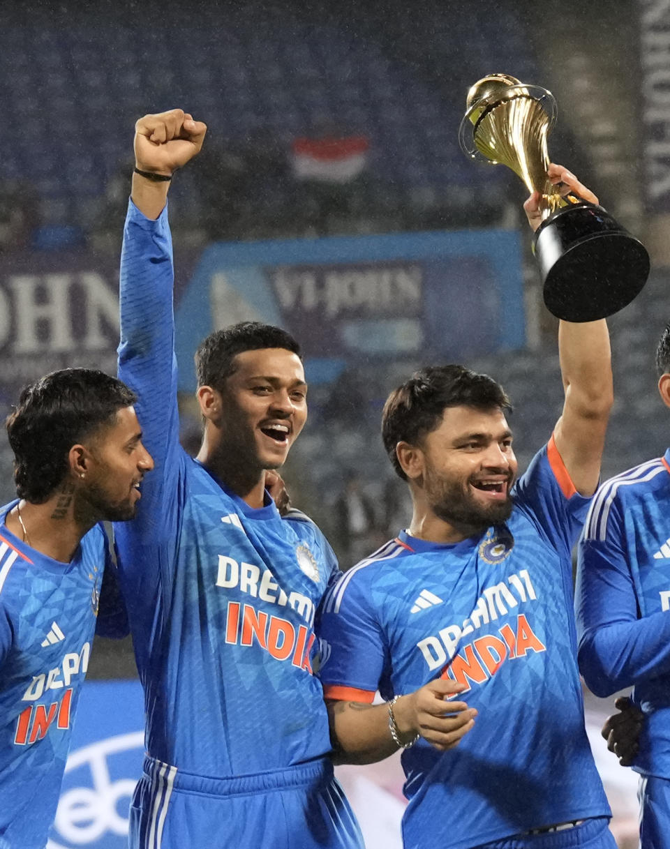 India's Rinku Singh, right, celebrate with his teammates as he holds the winners trophy after winning the fifth T20 match and series against Australia in Bengaluru, India, Sunday, Dec. 3, 2023. (AP Photo/Aijaz Rahi)