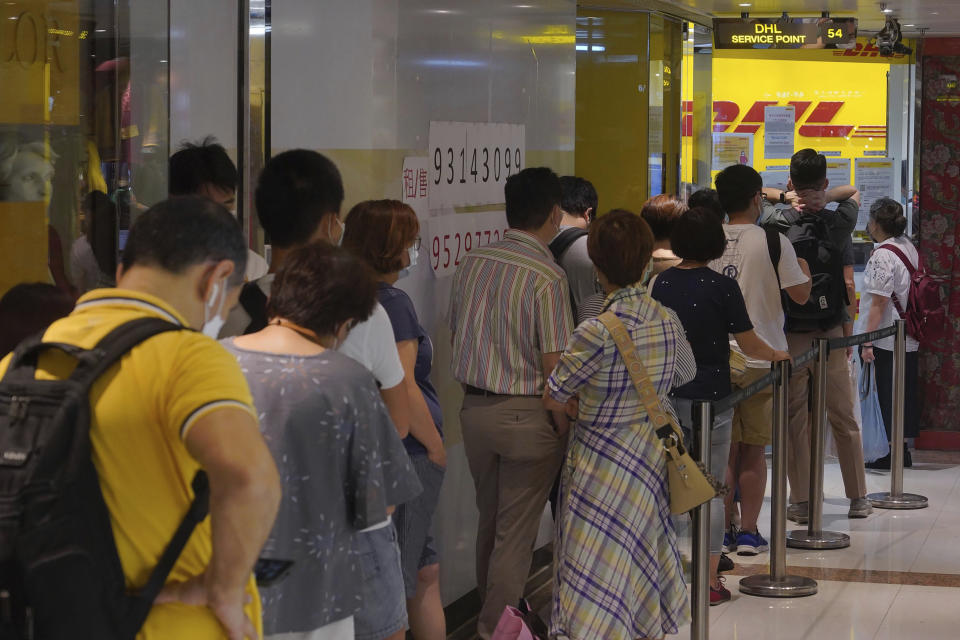 People queue up outside the DHL Express store in Hong Kong, Monday, June 1, 2020. Throngs of people lined up at DHL courier outlets across the city on Monday, many to send documents to the U.K. to apply for or renew what is known as a British National (Overseas) passport. (AP Photo/Vincent Yu)