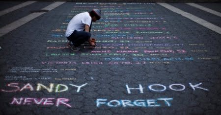 FILE PHOTO:  Street artist Mark Panzarino, 41, prepares a memorial as he writes the names of the Sandy Hook Elementary School victims during the six-month anniversary of the massacre, at Union Square in New York, June 14, 2013. REUTERS/Eduardo Munoz/File Photo