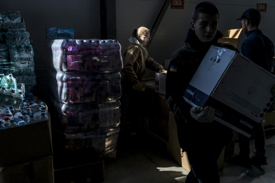 Melaniya Podolyak, a former political aide and now a manager of a warehouse bringing supplies for the Ukrainian military, center, sorts goods to be shipped out on April 13, 2022, in Lviv. (Brendan Hoffman for NBC News)