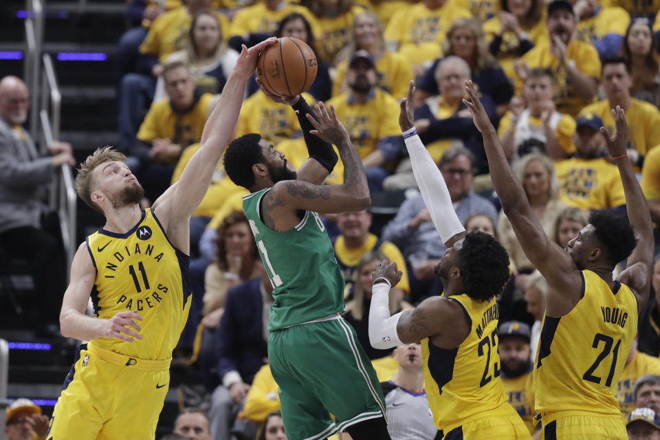 Boston Celtics' Kyrie Irving (11) has his shot blocked by Indiana Pacers' Domantas Sabonis (11) during the first half of Game 3 of an NBA basketball first-round playoff series Friday, April 19, 2019, in Indianapolis. Pacers' Thaddeus Young (21) and Wesley Matthews (23) also defend. (AP Photo/Darron Cummings)