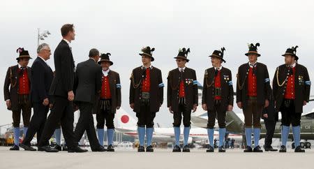 U.S. President Barack Obama shakes hands with men in traditional Bavarian attire as he departs Munich, Germany, at the end of the G7 Summit, June 8, 2015. REUTERS/Kevin Lamarque