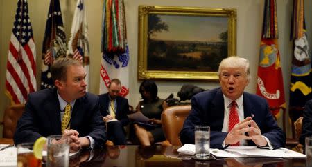 Director of the Office of Management and Budget Mick Mulvaney (L) listens to U.S. President Donald Trump speak during a "strategic initiatives" lunch at the White House in Washington, U.S., February 22, 2017. REUTERS/Kevin Lamarque