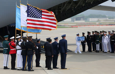 A U.N. honor guard carries a box containing remains believed to be from American servicemen killed during the 1950-53 Korean War after it arrived from North Korea, at Osan Air Base in Pyeongtaek, South Korea, Friday, July 27, 2018. Ahn Young-joon/Pool via Reuters