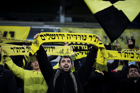 Betar Nordia Jerusalem fans hold up their team's scarfs as they cheer from the stands during a match at Teddy Stadium in Jerusalem, January 29, 2018. REUTERS/Ronen Zvulun