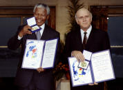 South African President F.W. de Klerk (R) and then-African National Congress leader Nelson Mandela (L) hold up medals and certificates after they were jointly awarded the 1993 Nobel Peace Prize at a ceremony December 10, 1993 at Oslo's city hall. (Reuters)