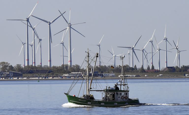 Un barco pesquero pasa frente a las turbinas eólicas entre la osla de Langeoog y Bensersiel en la costa alemana del Mar del Norte, 