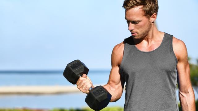 Strong bodybuilder man arm holding dumbbell doing lift exercise