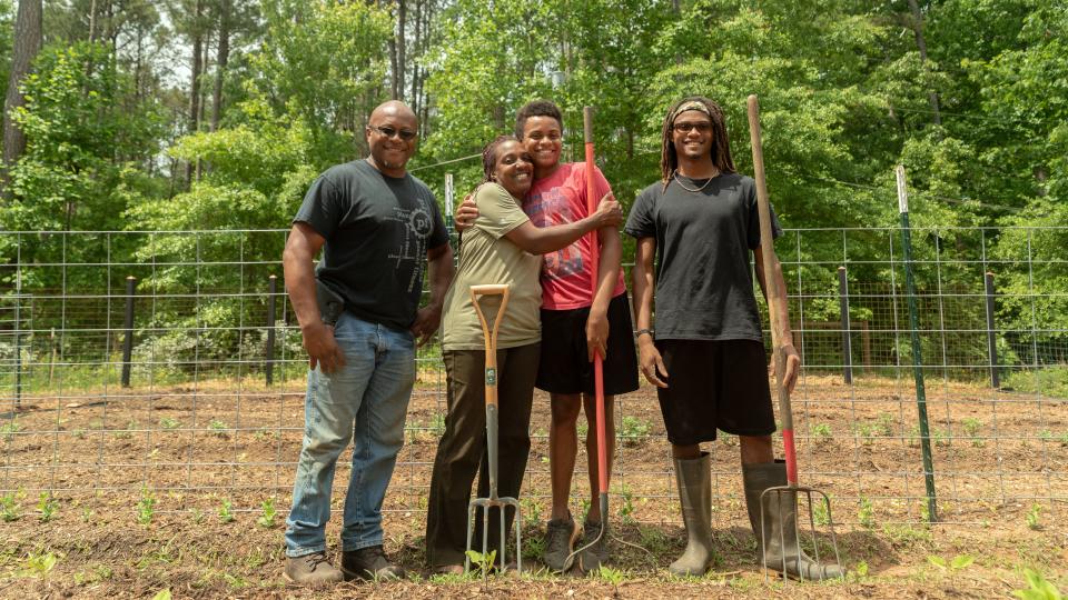 (L-R) Warren Cameron (husband), Keisha, and children Zachary and Abraham. The family owns High Hog Farm in Grayson, Georgia. (Photo: Lynsey Weatherspoon for HuffPost)