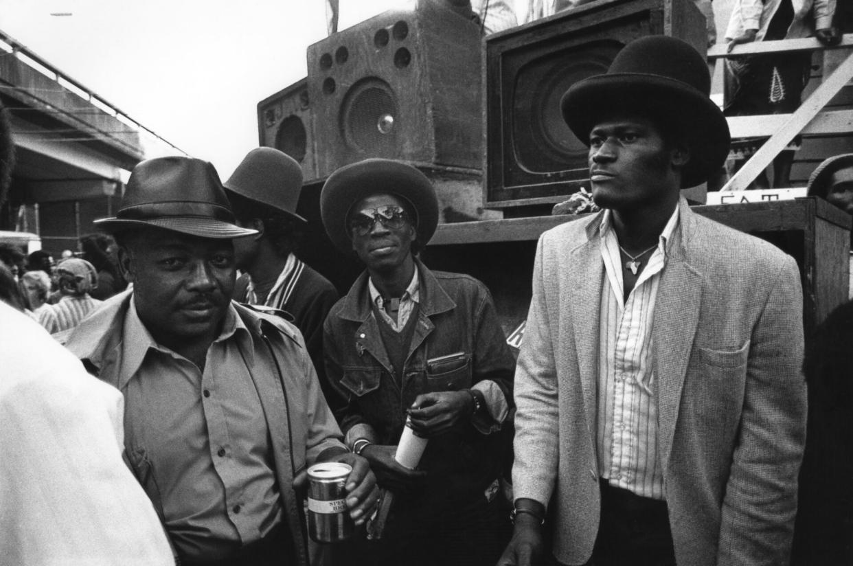 Three men enjoy the Sound System of Notting Hill Carnival in 1983 (Photo by Peter Anderson/PYMCA/Avalon/Getty Images)